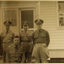 5 uniformed men in front of a house